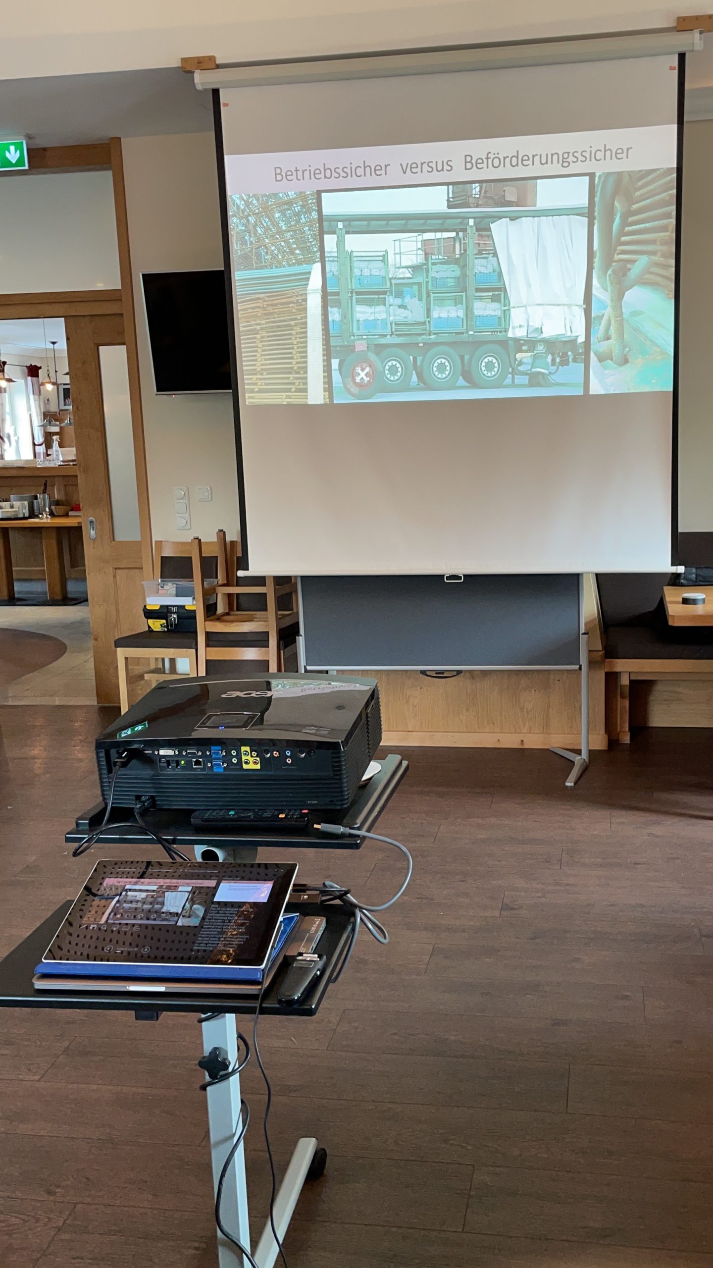 ein Beamer zeigt eine Präsentation von einem Laptop auf eine Leinwand in einem Seminarraum